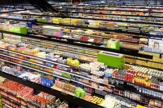 Vista aérea dos corredores de um supermercado, repletos de produtos coloridos.