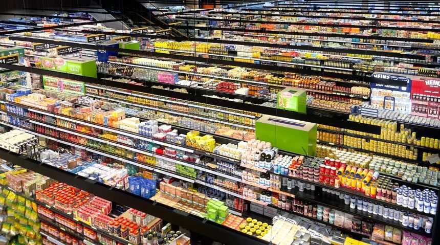 Vista aérea dos corredores de um supermercado, repletos de produtos coloridos.